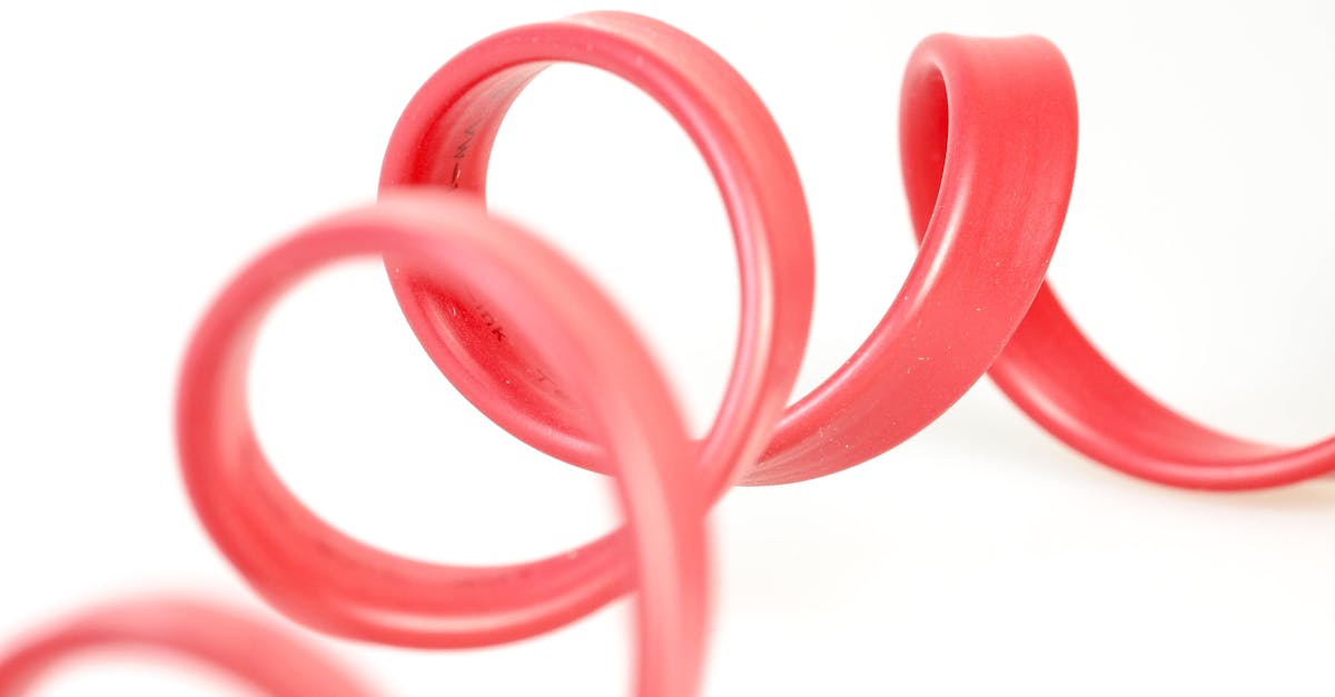 close up of a red rubber tube with elegant curves against a white background